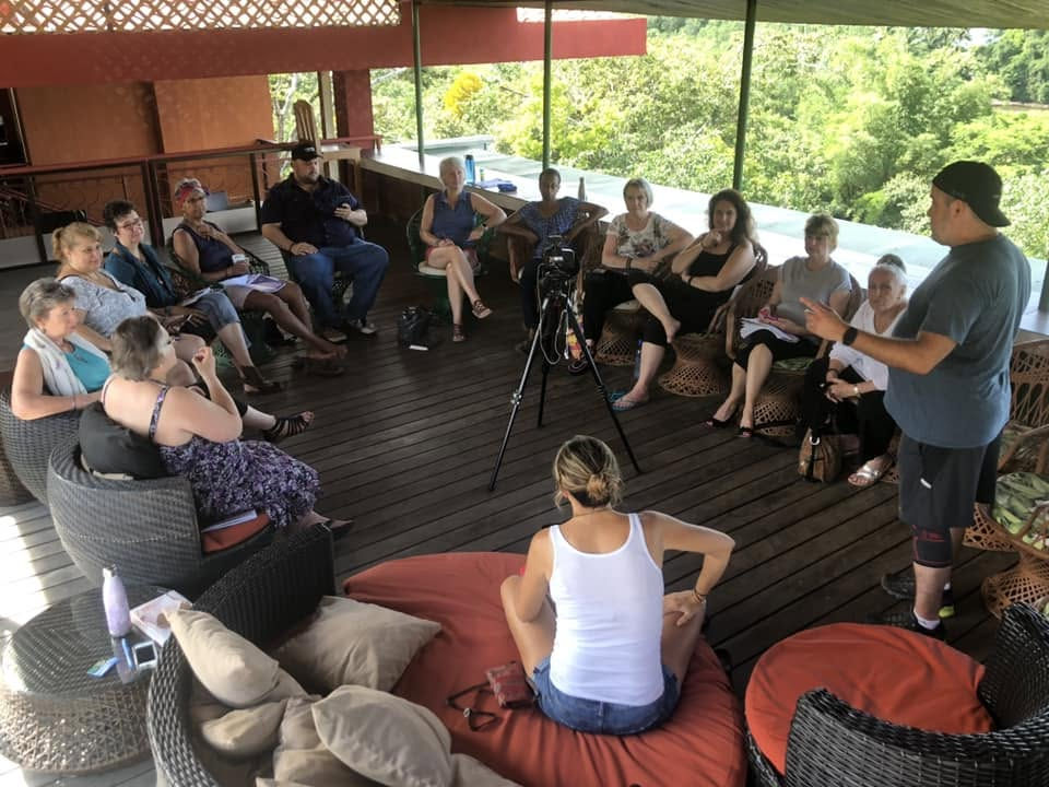 Retreat group sitting in a circle on a villa deck during an integration session